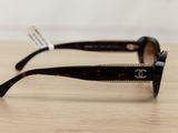 sunglasses on a wooden table with a white wall in the background