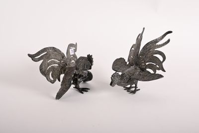 une paire de figurines de coqs en métal sur fond blanc