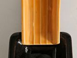 a black plate with a yellow candle holder on top of it