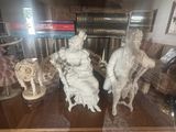 des statues représentant des personnes assises sur un banc, exposées dans une vitrine