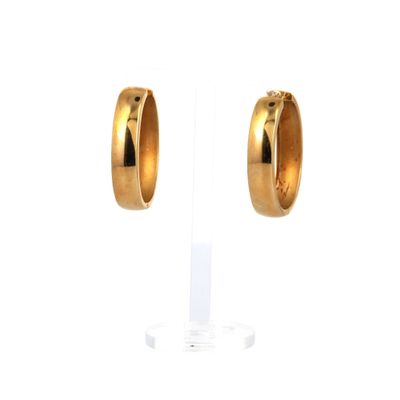 une paire de boucles d'oreilles en or sur fond blanc