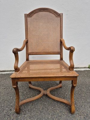 an old wooden chair with cane back and cane seat