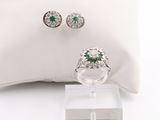pair of emerald and diamond earrings and ring on a white pillow