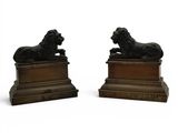 paire de serre-livres en bronze représentant des lions, sur des socles en bois