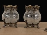 three silver vases sitting next to each other on a table