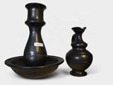 two black vases sitting next to each other on a table