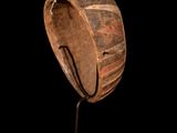 a large wooden bowl on a stand against a black background