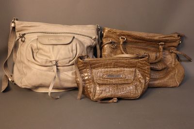 several purses are lined up on a gray surface