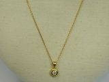 a gold necklace with a diamond on a mannequin head