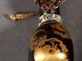 a black and gold bottle with a gold dragon on it