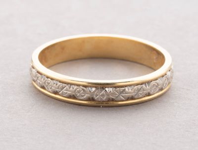 a close up of a gold wedding ring on a table