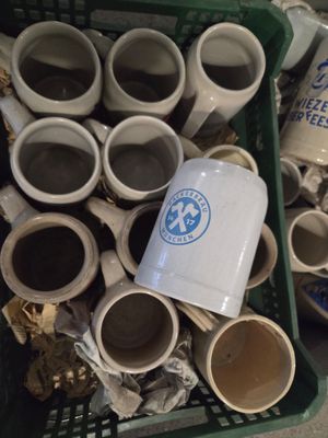 de nombreuses tasses de café dans un panier posé par terre