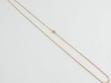 a gold chain necklace with a small diamond on it