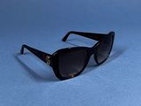 black sunglasses on a blue surface with a white background