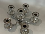 a silver candle holder on a table with a white background