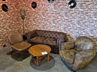 un canapé, une chaise et une table dans une pièce aux murs en briques