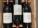 several bottles of wine are in a wooden crate on a counter