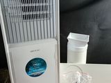 a small air conditioner sitting on a table next to a remote control