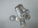une pile de pièces d'argent posée sur une surface blanche