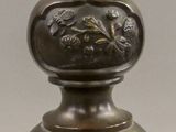 a bronze vase that is sitting on top of a table