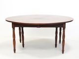 La table est en bois et possède un plateau rond.