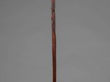 a wooden pole with a wooden handle and a metal base