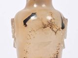 un vase en verre avec un couvercle vert posé sur une surface blanche