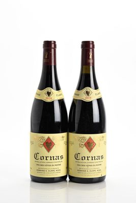 two bottles of red wine sitting next to each other on a white surface