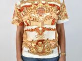 the woman is wearing a t - shirt that has a gold and red design on it