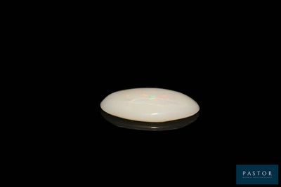 a white frisbee that is sitting on a black surface