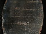 a metal plate with a hole in it on a black background