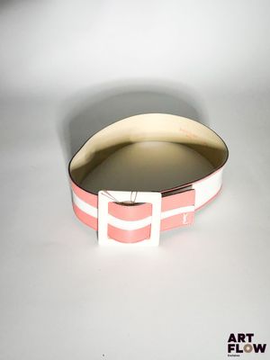 une photo d'un bracelet rose et blanc posé sur une surface blanche