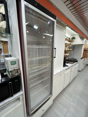 un réfrigérateur au milieu d'un magasin rempli de produits alimentaires