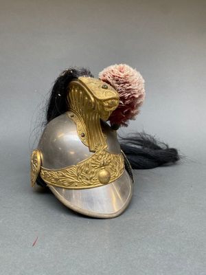 un casque orné d'une plume, posé sur une table