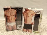 two boxes of men ' s underwear sitting on a bed next to each other