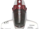 un aspirateur rouge et argent posé sur une table blanche