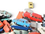 many toy cars sitting on top of each other on a white surface