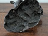 a sculpture of a bird sitting on a rock on a table