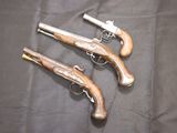 three old guns are sitting on a black cloth