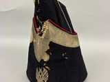 un vieux chapeau noir orné d'une bordure dorée et d'un ruban doré