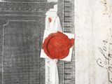 a red wax seal sitting on top of a piece of paper