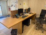a desk with two computers and a chair in front of it