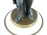 a bronze statue of a woman sitting on a pedestal