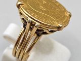 a close up of a gold ring with a coin on it