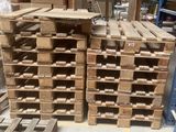 de nombreuses palettes en bois empilées les unes sur les autres dans un entrepôt