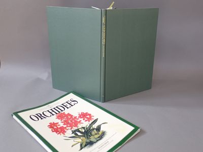 un livre vert sur lequel figure l'image d'une fleur rouge