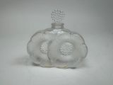 une petite bouteille en verre ornée d'un motif floral