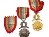 three medals and a medal are sitting on a white surface