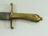 a close up of a gold sword on a white surface