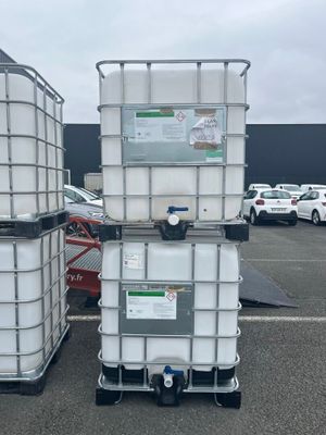two large white containers sitting on top of each other in a parking lot